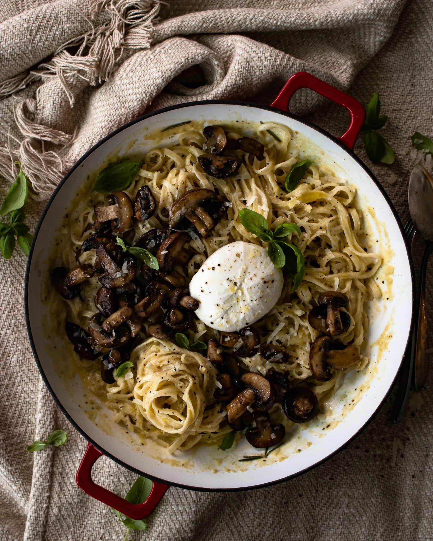 Overhead shot of White Wine Pasta with Roasted Mushrooms in a large white enamel skillet with red handles