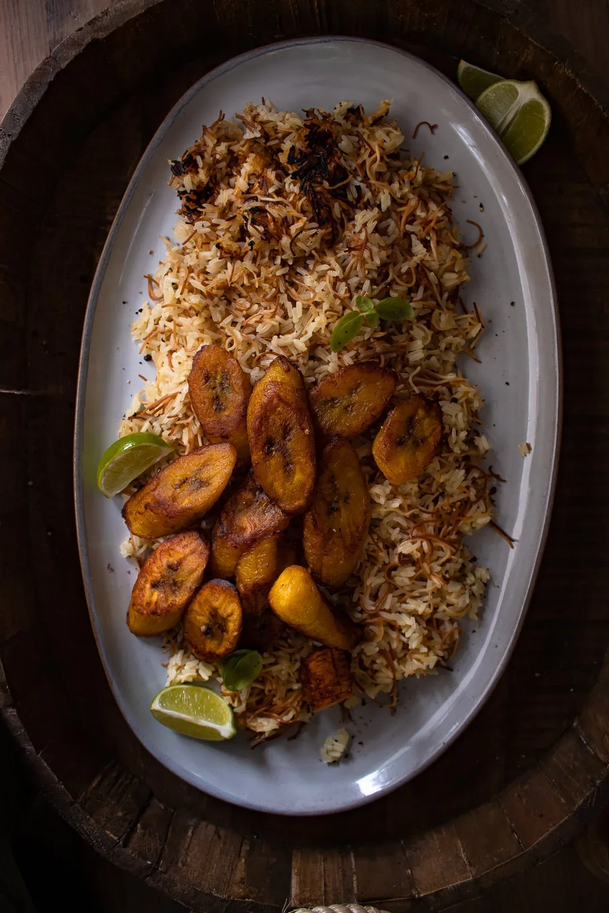 Arroz con Fideos (Dominican Rice and Fried Noodles) mounded on a grey oval platter with golden toasted fideos threaded through fluffy rice
