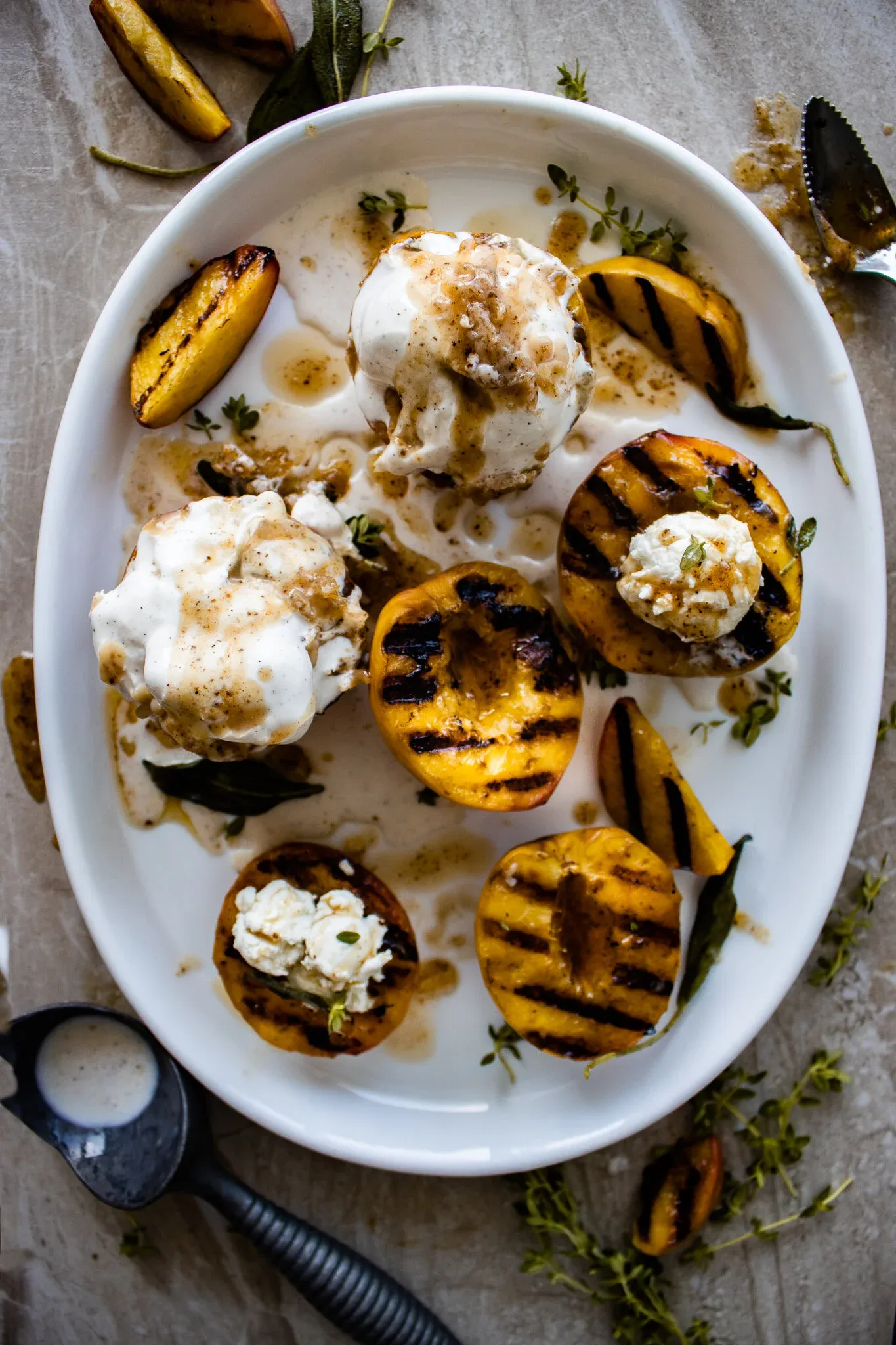 Overhead white oval platter of maple brown butter stuffed grilled peaches